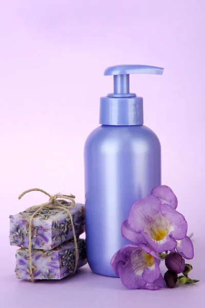 Liquid and hand-made soaps on purple background