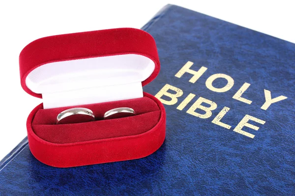 Wedding rings on bible isolated on white