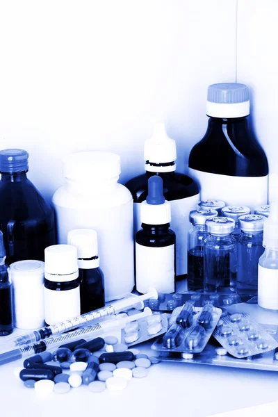 Medical bottles and pills in blue light