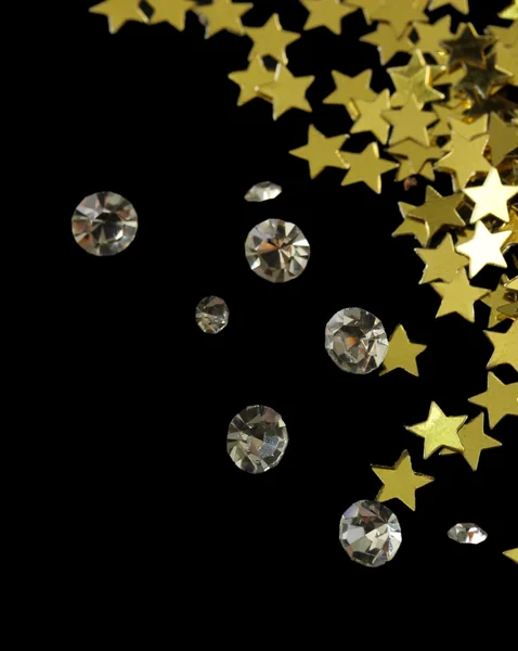 Beautiful shining crystals (diamonds) and golden stars, on black background
