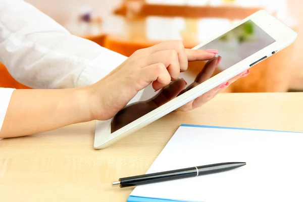 Female office worker using digital tablet in cafe