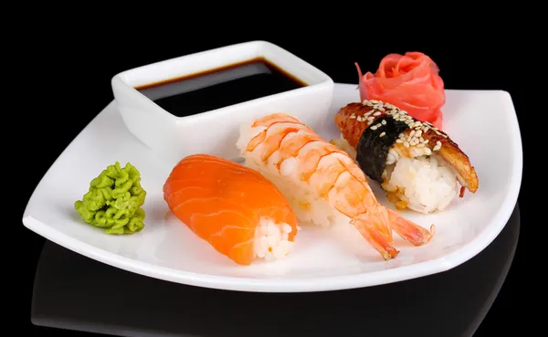 Delicious sushi served on plate isolated on black