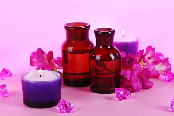 Spa oil and freesia on purple background