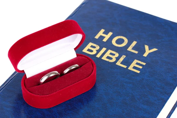 Wedding rings on bible isolated on white