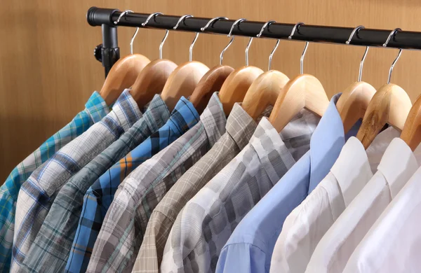 Men's shirts on hangers in wardrobe — Stock Photo #23940179