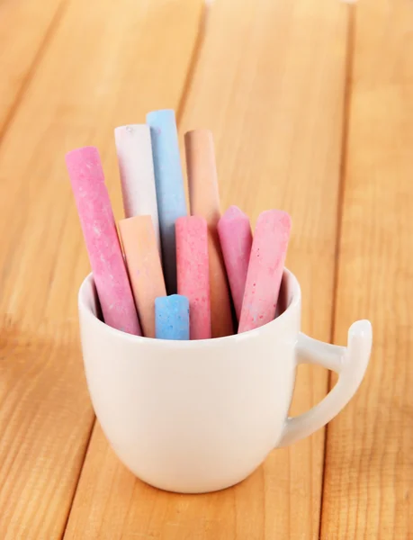 Colorful chalk in cup on table