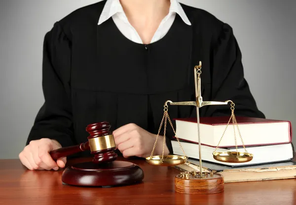 Judge sitting at table during court hearings on grey background