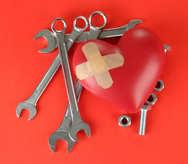 Heart and tools. Concept: Renovation of heart. On color background