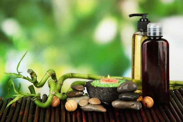 Still life with green bamboo plant and stones, on bamboo mat, on bright background