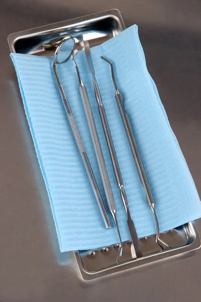 Dentist tools on grey table close-up