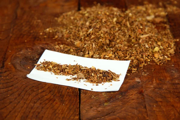 Tobacco and rolling paper, on wooden background
