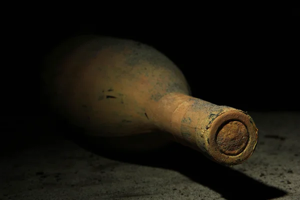 Old bottle of wine in old cellar, on dark background