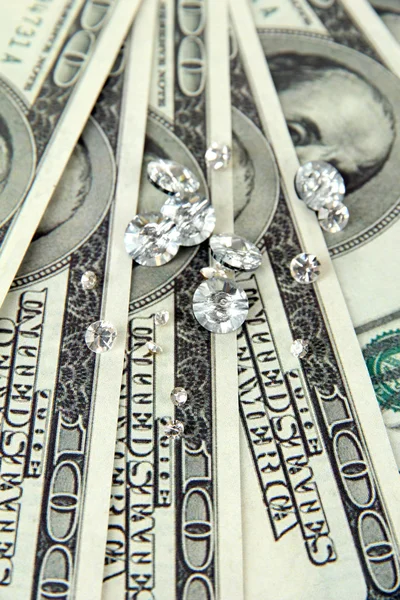Beautiful shining crystals (diamonds) on money background