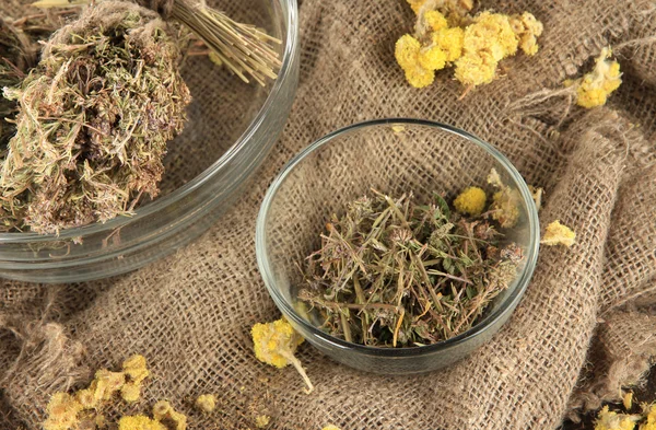 Medicinal Herbs in glass bowls on bagging close-up