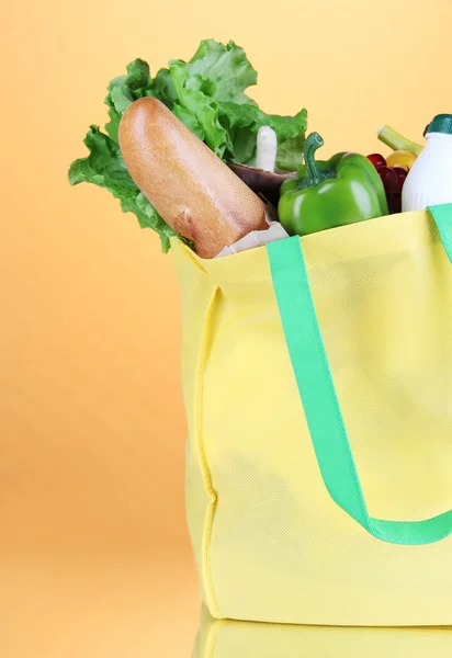 Eco bag with shopping on orange background