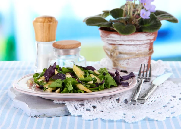 Light salad on plate on table on room background