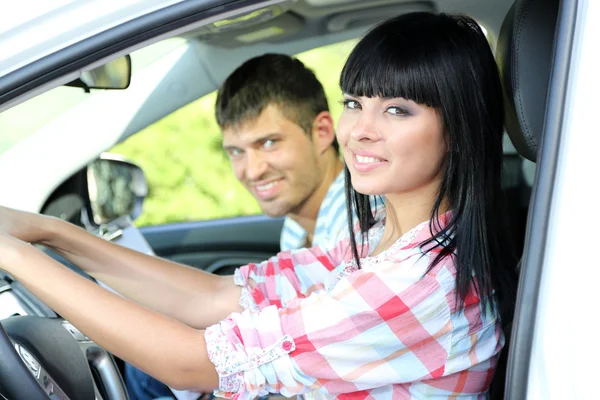 Beautiful young woman taking driving lesson