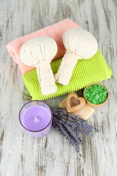 Still life with lavender candle, soap, massage balls, soap and fresh lavender, on wooden background