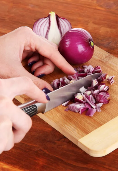 Cutting purple onion on wooden background