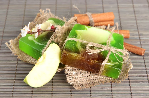 Hand made soap and ingredients for soap making on grey bamboo mat