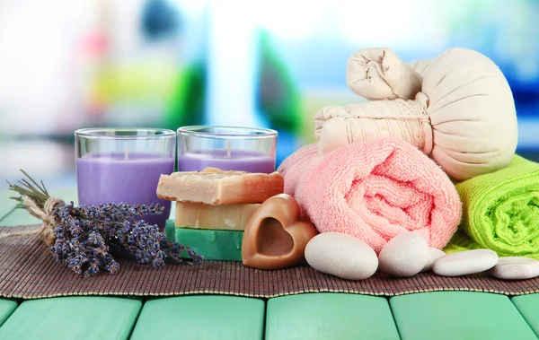 Still life with lavender candle, soap, massage balls, soap and fresh lavender, on bright background