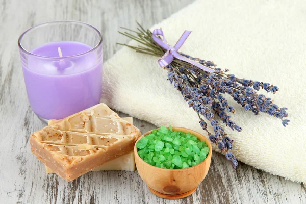 Still life with lavender candle, soap, soap and fresh lavender, on wooden background