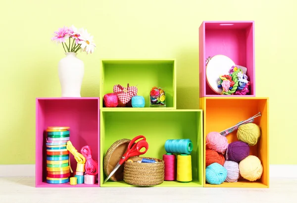 Colorful shelves of different colors with utensils on wall background