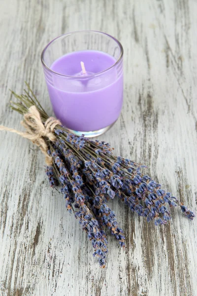 Lavender candle with fresh lavender, on wooden background