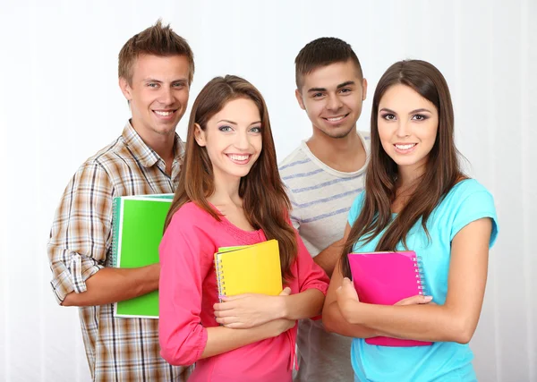 Group of happy beautiful young students at room