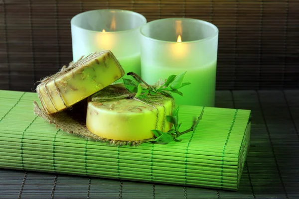 Hand made soap and candles on bamboo mat background