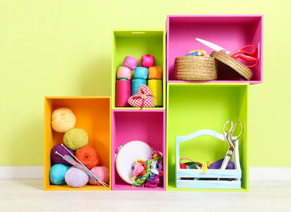 Colorful shelves of different colors with utensils on wall background