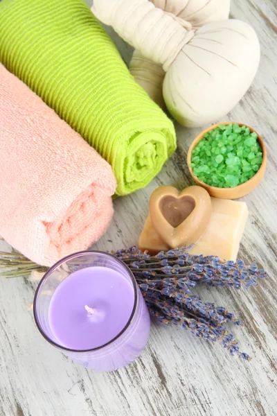 Still life with lavender candle, soap, massage balls, soap and fresh lavender, on wooden background