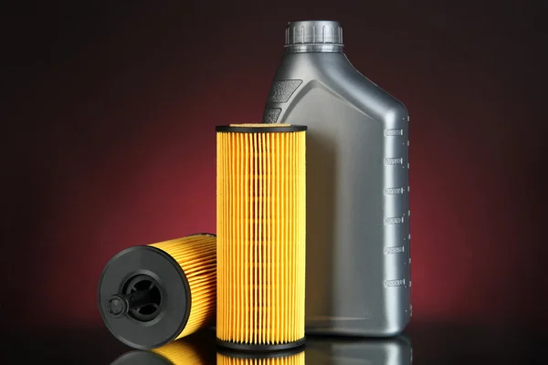 Car oil filters and motor oil can on dark color background