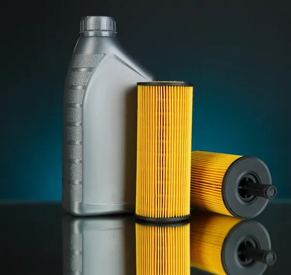 Car oil filters and motor oil can on dark color background