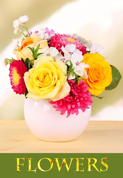 Beautiful bouquet of bright flowers in vase on bright background