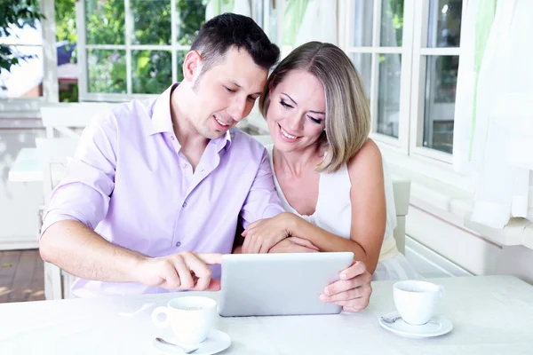 Young couple taking photo with tablet in restaurant