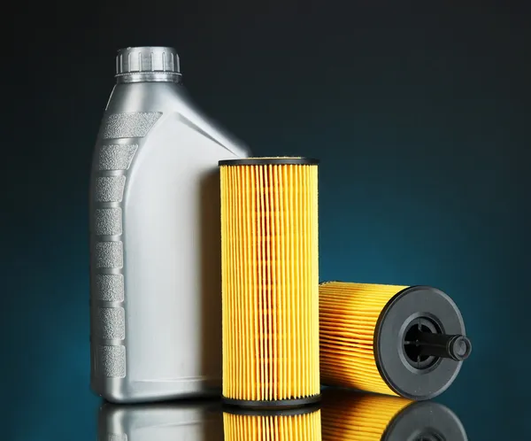 Car oil filters and motor oil can on dark color background