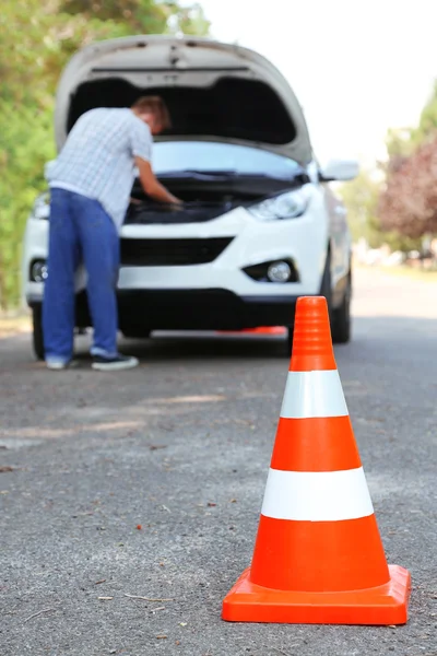 Broken down car with warning cone
