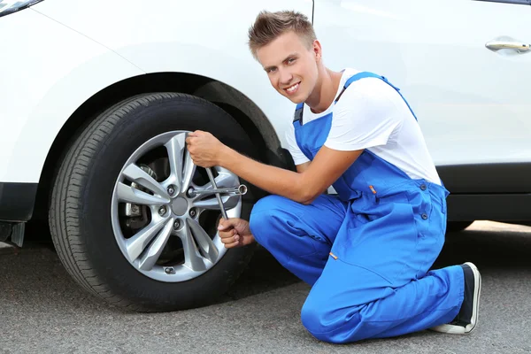 Auto mechanic changing wheel