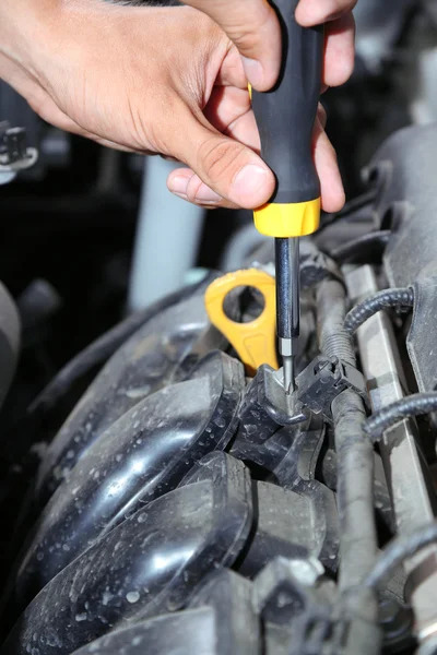 Hand with screwdriver. Auto mechanic in car repair
