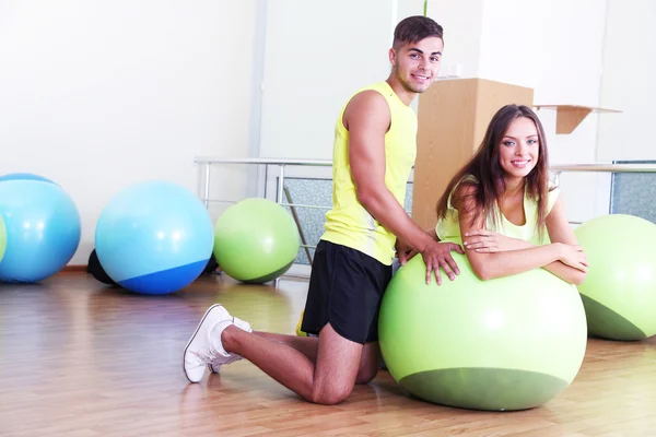 Girl and trainer engaged in fitness room