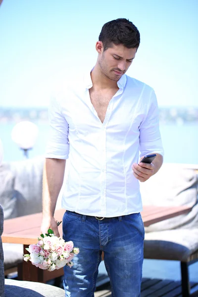 Handsome with bouquet of roses man waiting a woman