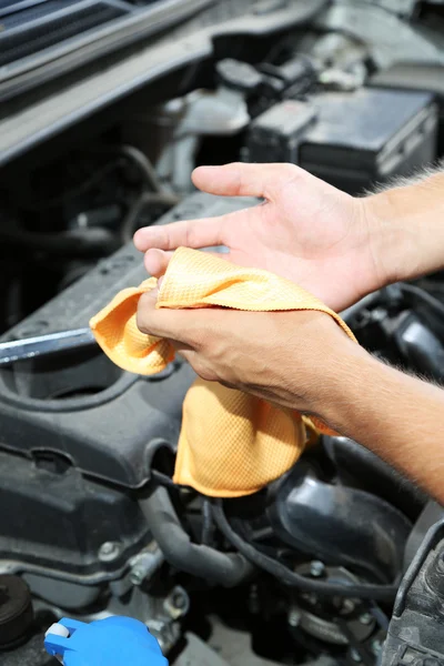 Motor mechanic cleaning his greasy hands after servicing car