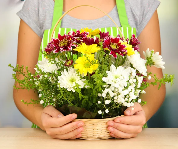 Florist makes flowers bouquet in wicker basket