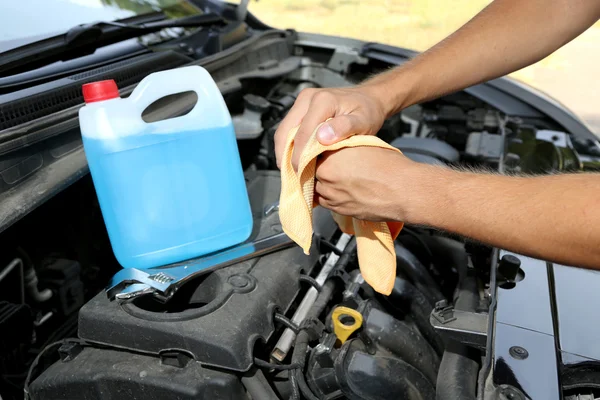 Motor mechanic cleaning his greasy hands after servicing car