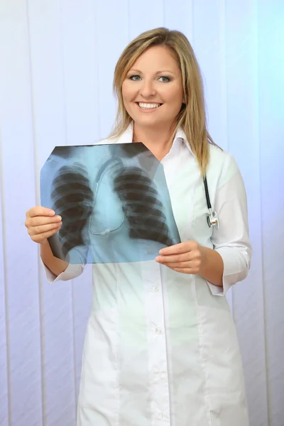 Medical doctor analysing x-ray image on light background