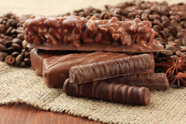 Delicious chocolate bars with coffee beans close up