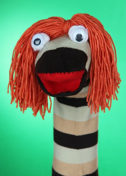 Cute sock puppet on green background