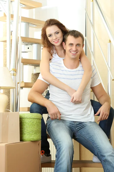 Young couple sitting on stairs in new house