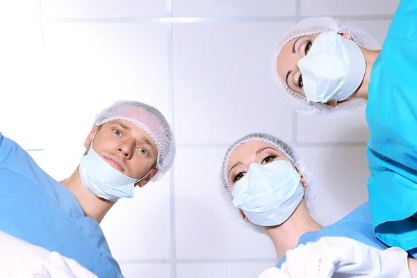 View from below of surgeons in protective work wear during operation